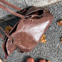 画像をギャラリービューアに読み込む, 落ち葉の舞う並木道で少女が抱えたクラシカルレザーバッグ_K0190