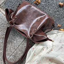 画像をギャラリービューアに読み込む, 落ち葉の舞う並木道で少女が抱えたクラシカルレザーバッグ_K0190