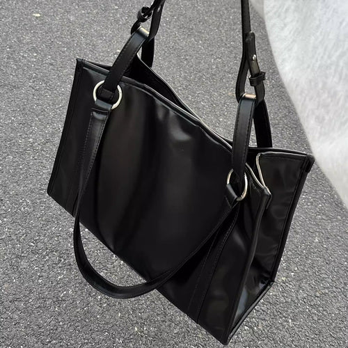 都会の雑踏を抜けてカフェに立ち寄る女のシックレザートート_K0179